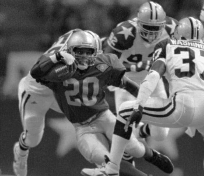 Lions running back Barry Sanders (20) looks for a way around Cowboys James Washington (37), Sept. 19, 1994, in Irving, Texas.